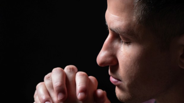 Praying man on a black background