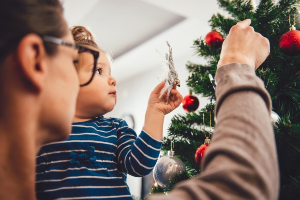Mom and daughter decorating Christmas tree